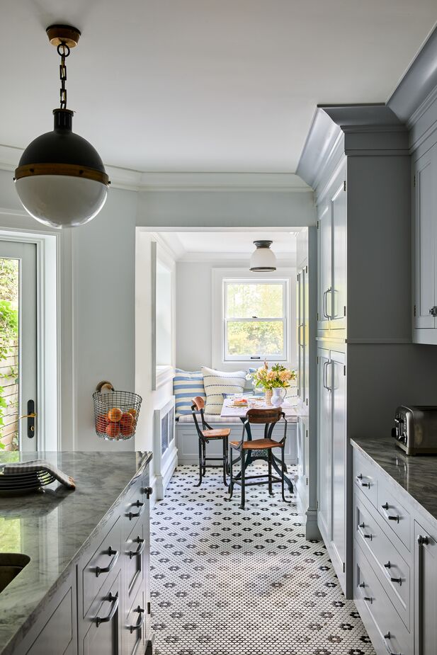 Though the kitchen was reconfigured, its penny-tile floor reflects its past. Find the lighting pendant here.   
