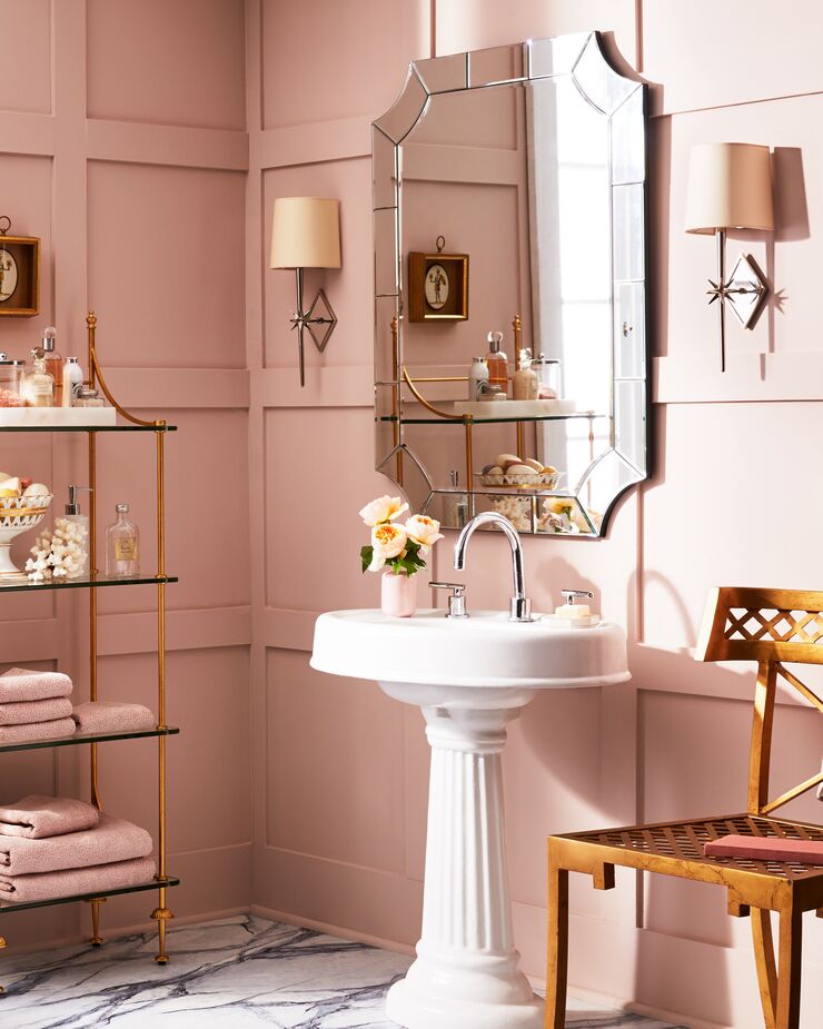 In a bathroom without a vanity, a chair can pinch-hit for counter space, and an étagère (like the Kary shown here) can provide storage. Find the sconces here. 
