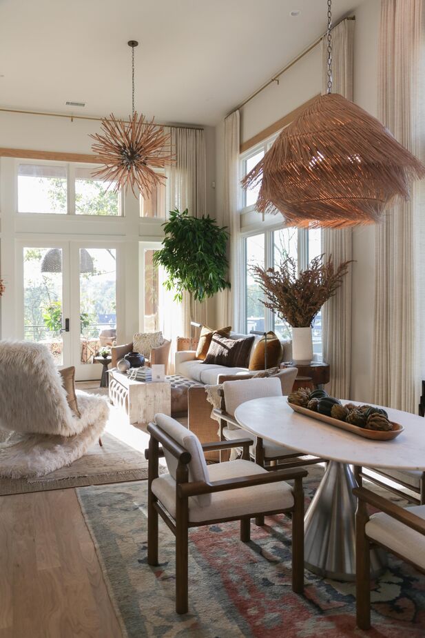 In this living/dining area, Melody Richardson and Marlee Vlassis of Balance Design opted for furnishings with natural finishes that were also substantial enough to hold their own against the high ceilings and large windows. The Ashburn Pendant over the dining table is one such piece.
