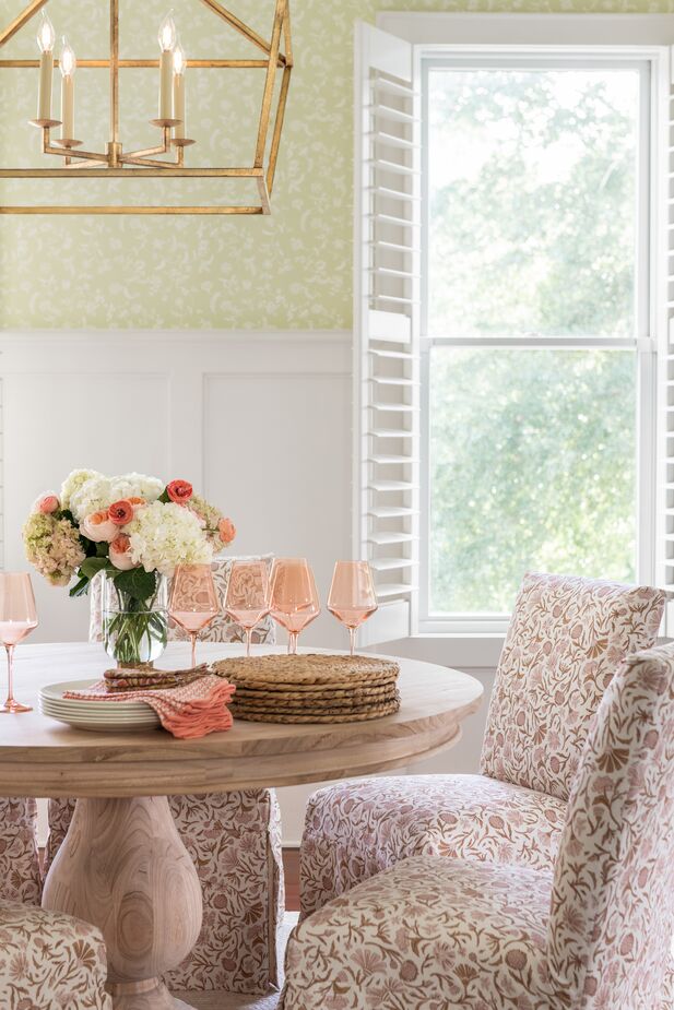 Pink stemware brings a springlike cheer to plain white dishes; in winter it can be swapped out for ruby or emerald glassware. Find the dining table here and the chairs here. Room by One Kings Lane Interior Design. Photo by Katie Charlotte Lybrand.
