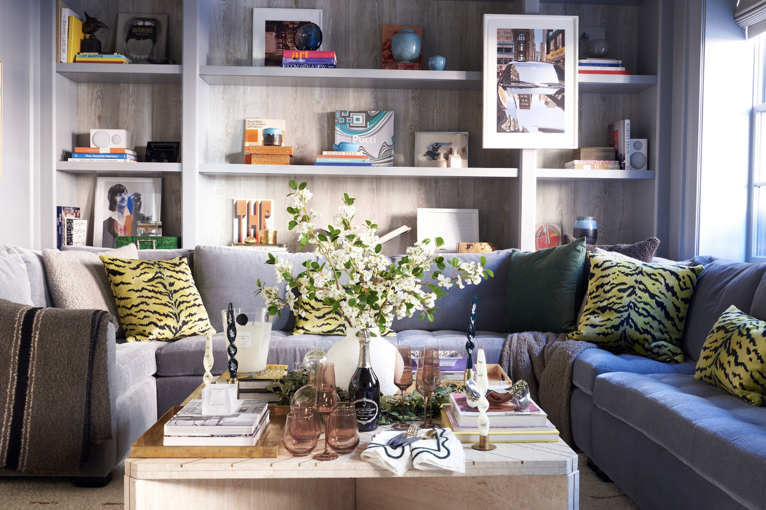 The citron animal-print pillows and the pops of orange on the shelves warm up the family room’s cool grays—and demonstrate Ashley’s love of using accents to make a space uniquely hers.
