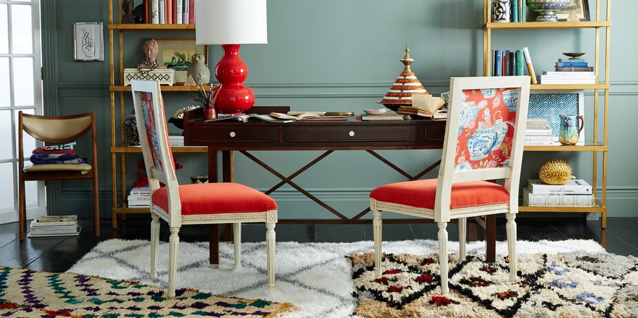 A simple desk is a quiet complement to colorful chairs and layered Moroccan rugs. Find a similar lamp here.  
