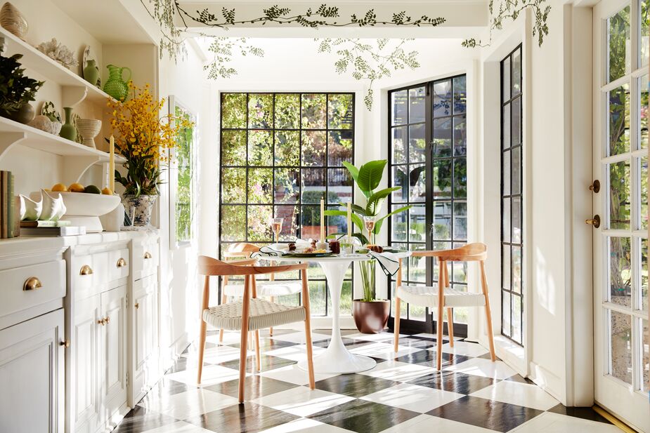 The foliage painted on the walls of this breakfast room extend onto the ceiling, giving the space the gracefulness of an arbor. Find the dining table here and the faux bird-of-paradise tree here. Photo by Joe Schmelzer.
