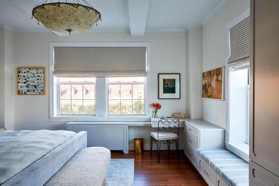 In the primary bedroom, “it was important to use different textures to add dimension,” Maggie says. Those textures include the silk Fortuny chandelier and the sheepskin bench.
