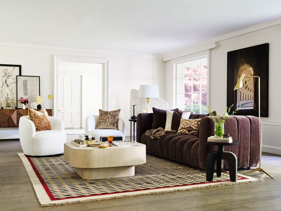 Sumptuous textures and sleek curves form the foundation of this Curator-chic room. The Darcy Performance Velvet Sofa in Java and the Chester Bouclé Swivel Chairs in Snow bring pampering softness, while the glimmer of the Penelope Floor Lamp in Brass adds timeless glamour. Find the rug here, the coffee table here, and the accent table here. Photo by Joe Schmelzer.  
