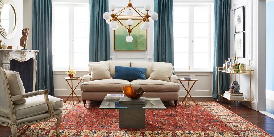 Turned legs and English arms ensure that the Brooke 2-Seat Sofa looks elegant enough for a traditional living room; its loose seat and back cushions prevent it from looking overly formal. Find the Finn Bar Cart here and a similar chandelier here.
