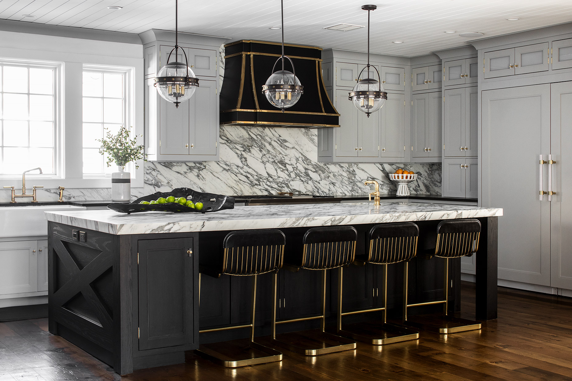 “I find that most of my clients want a light, bright, and airy room, so cladding a kitchen in a heavier color or dark tones needs to be offset with tons of natural light and an open floor plan or higher ceilings,” says Karen Wolf of Karen B. Wolf Interiors. The gleaming brass hardware and fixtures provide a bright contrast to the black. Opting for a matte finish on the island also dials down the intensity of the black. Photo courtesy of Karen B. Wolf.
