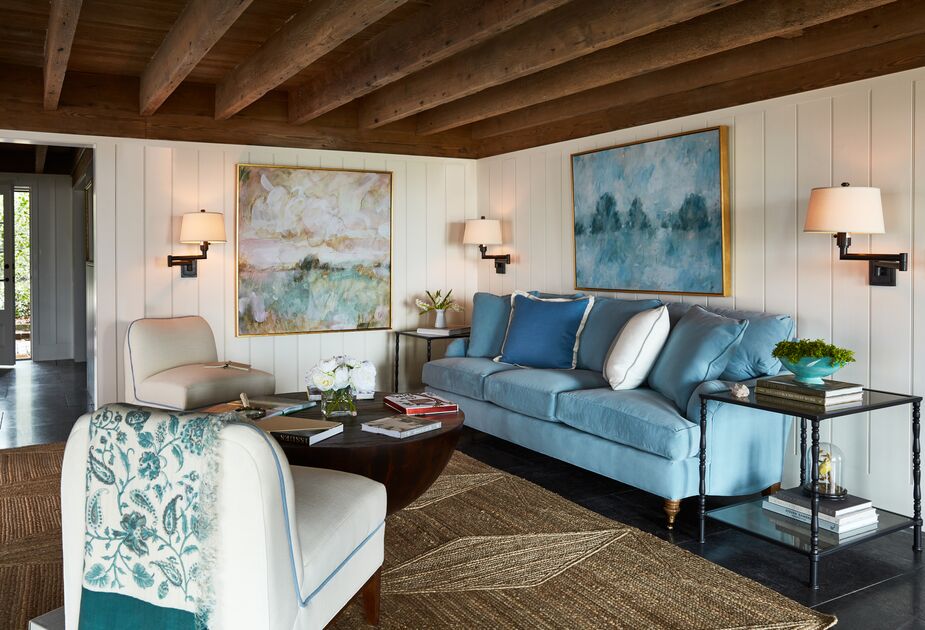 Dimmer switches are one way to vary the brightness of a room. Another is to place multiple sconces in a room. Here, you could turn on all three for maximum brightness and use just one or two otherwise. Swing-arm sconces such as those above offer even more versatility. Shown above: the Brooke 3-Seat Sofa in Light Blue Crypton Velvet, the rug Peyser Jute Rug, Coffee Fields by Laura Roebuck (left) and Cloudland, also by Laura Roebuck, above the sofa. Photo by Frank Frances.
