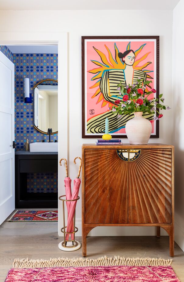 Despite its compact size, this formal entry packs quite a visual punch thanks largely to the bold artwork. The equally striking vintage cabinet provides always-welcome storage.
