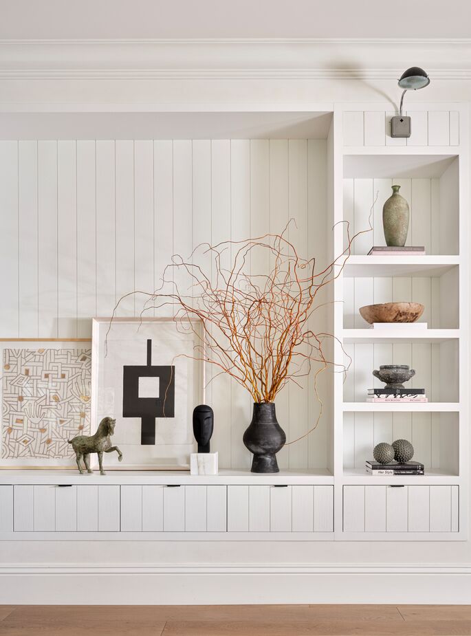 Accents and artwork in black and dark gray, such as the Isaac Sculpture (inspired by the moai of Easter Island) and the (confusingly named) Amber Vase, make a strong statement among paler neutral hues. Find the black-and-white abstract, Centered I, here and the dried mountain laurel branches here.
