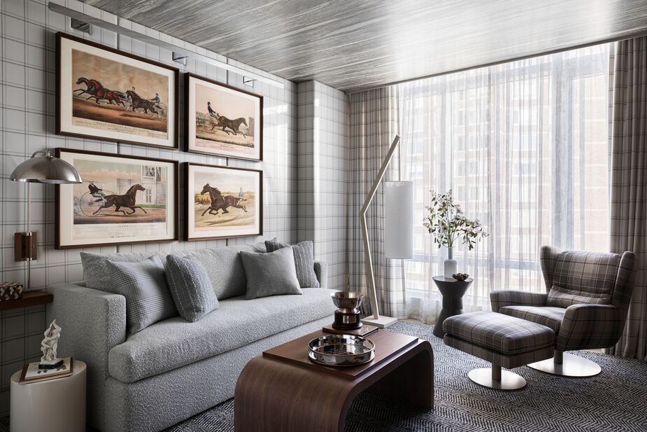 The plaid walls, drapes, and chair, along with the herringbone rug, are key to the den’s clubby feel. Because the husband owns a racehorse, Andrew chose to hang racing prints.
