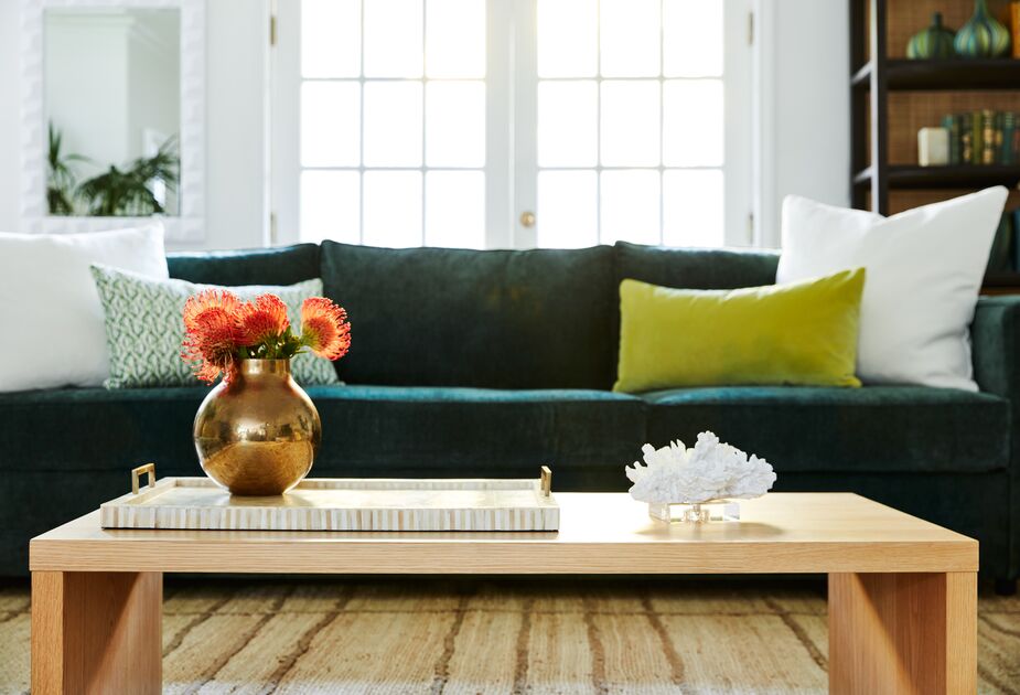 With its handles and raised sides, the Bone & Brass Tray helps prevent spills when serving guests—and looks great when adorning a cocktail table. Also shown: the Duke Coffee Table in Oak and the stain-resistant Stanton Performance Velvet in Evergreen.
