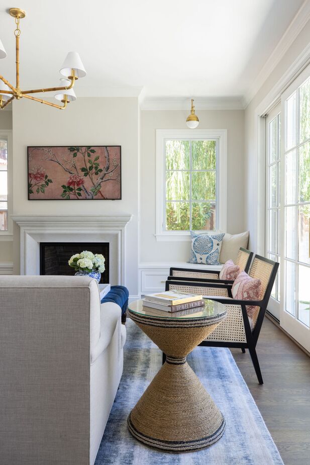 The cane panels of the chairs (find similar ones here) and the seagrass wrapped around the Redfield Accent Table introduce always-welcome natural textures. Placing a Hicks Library Sconce above each window seat makes them cozy reading nooks at night.
