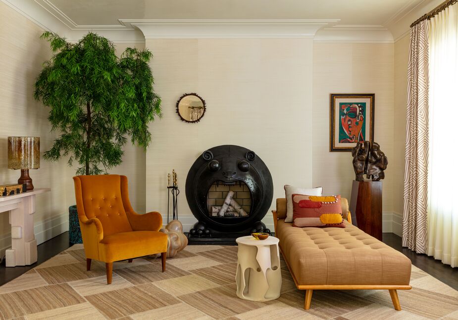 The bronze fireplace surround by sculptor Jean-Marie Fiori, resembling a roaring tiger, is a focal point in David Scott’s reimagining of a Moderne parlor. The daybed and the wingback chair flanking it hold their own, however, thanks to their strong silhouettes. The quiet palette and the disciplined curation of objects ensure an inviting serenity. 
