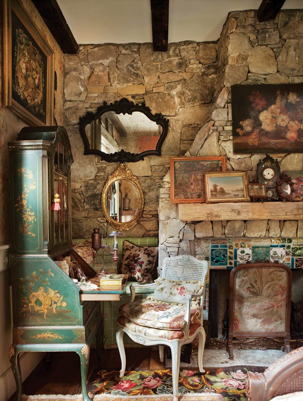 While the graceful carved furnishings lean heavily toward luxe, the stone wall and the weathered wood mantel keep the lodge element prominent.
