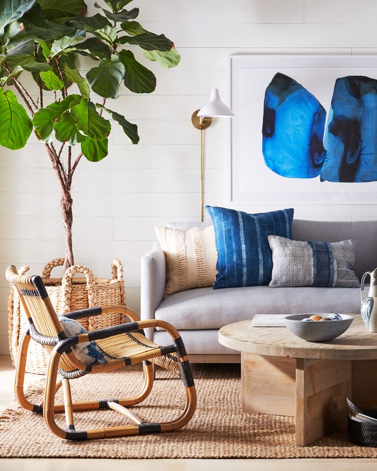 Hiding the tree’s bland pot in a wicker basket reinforces the sunroom’s indoor/outdoor ease. Amid the earthy elements such as the Landry Coffee Table (made of reclaimed wood), the abstract artwork and the Charlton Sconce add contemporary sophistication. Find a similar sofa here and a similar rug here.
