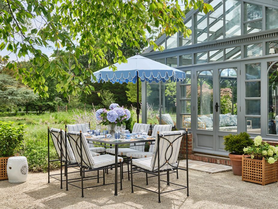 Nicky opted for the Frances Seven-Piece Dining Set in Linen Indigo Stripe. “It has size and proportion, which allows us to host big or small groups comfortably,” she says. “The fabrics are beautiful as well, which is not always easy to find with outdoor cushions.” The Phoebe Scallop Patio Umbrella (shown here in Light Blue) is a must for sunny days. 
