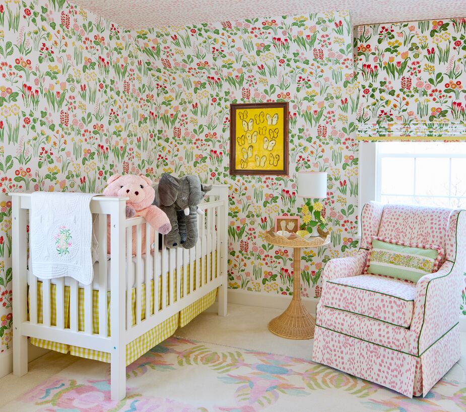 The floral wallpaper transforms the nursery into an enchanted garden. The pink dots of the ceiling match those of the chair’s upholstery, while the chair’s green piping connects it to the wallpaper.
