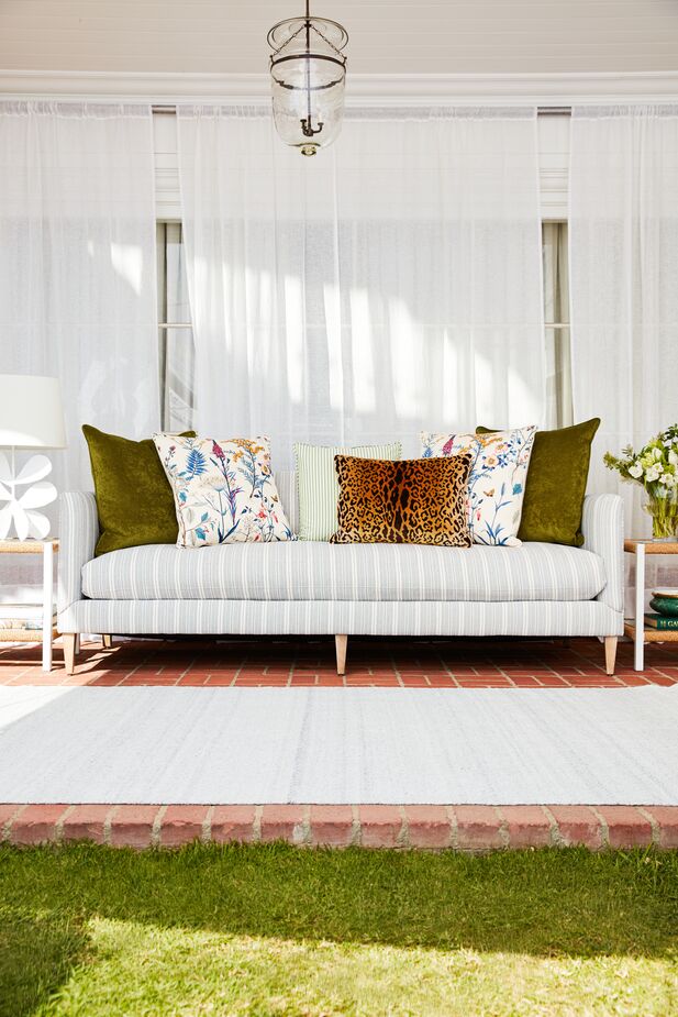 Adding two Hazel Pillows in Balsam Velvet and a vintage leopard-print pillow to the Camila Wide-Stripe Sofa makes it feel more autumnal—and more glam. Find the table lamp here. Photo by Joe Schmelzer.
