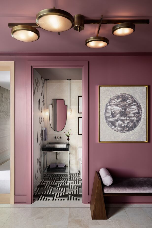 The powder room offers a monochromatic contrast to the foyer’s attention-grabbing mauve walls. 
