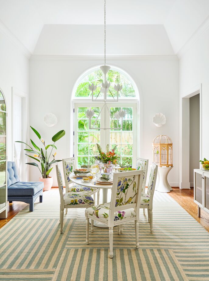 Above: the Canyon Stripe Patch Rug in Sky, the Exeter Dining Chair in Lemon Floral, and the Alberto Medium Two-Tier Chandelier in Plaster White. 
