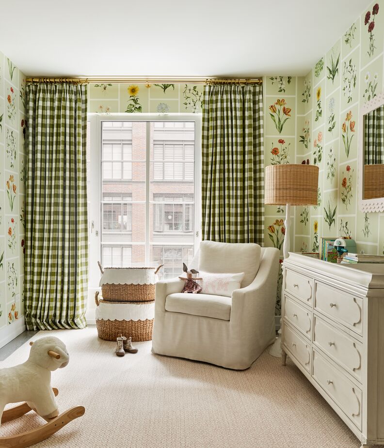 Because the large-scale wallpaper print and the smaller-scale gingham curtains are in the same color family, the nursery retains a soothing ambience. Find a similar swivel chair here. 
