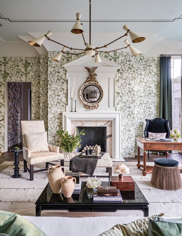 By adding contemporary touches such as the midcentury-style chandelier and the abstract fabric on the armchair and ottoman, Ashley Gilbreath incorporated an element of surprise into this otherwise-traditional living room. Find the sculptural drinks table here; find a pillow similar to that on the armchair here. 

