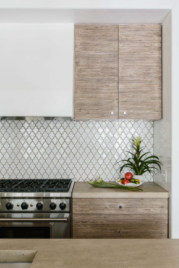 “The kitchen cabinet doors are a white oak reeding that was then stained, which is one of our favorite details,” Susan says. “There is a modernity to the reeding, but it also speaks to tropical style of the past and could be of any time period—vintage or modern.”
