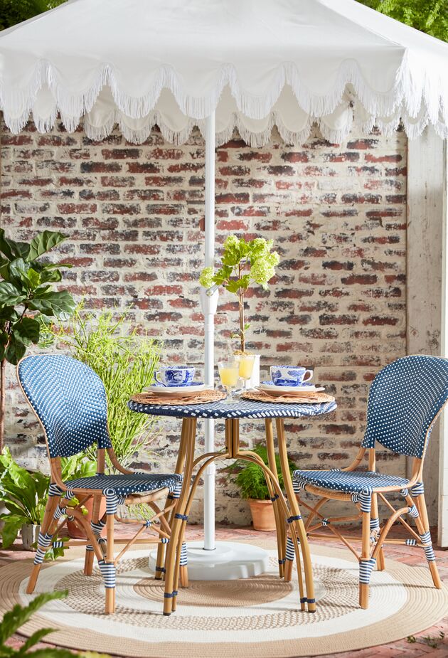 The Aya Fringe Patio Umbrella in White gives shade to the bistro set (find similar bistro chairs here). The Round Laney Outdoor Rug in Cuban Sand adds definition to the cozy dining area. Photo by Tony Vu.
 
