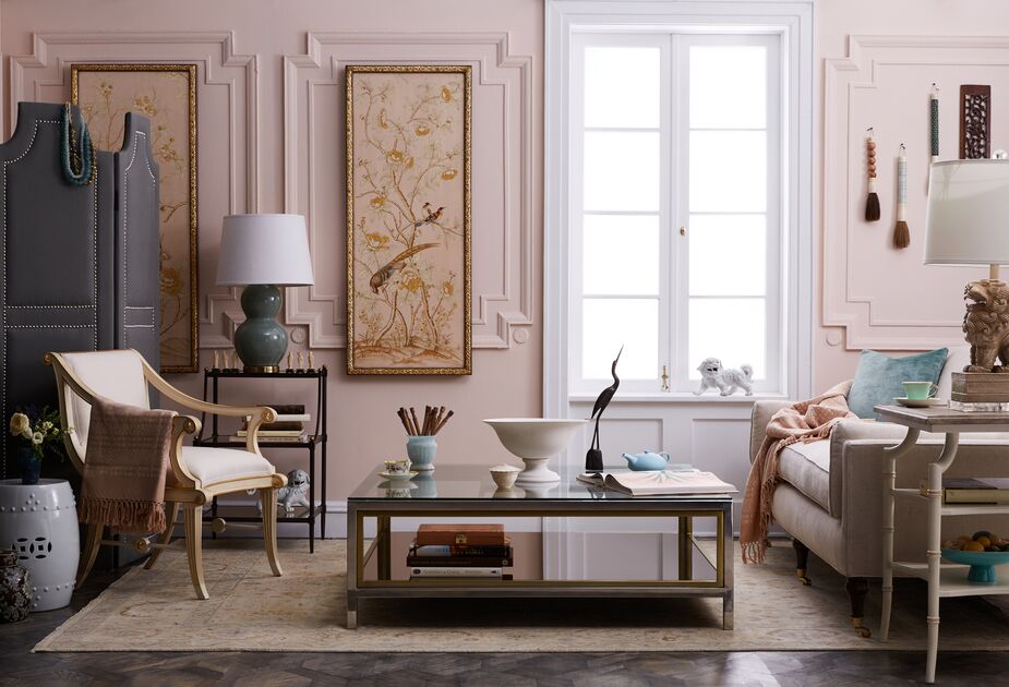 Dusky rose walls contribute to the serenity of this classically elegant living room. The even softer pink of the chinoiserie panels, the velvet sofa, and the rug ensure cohesiveness. Find the accent chair here and the garden stool here.   
