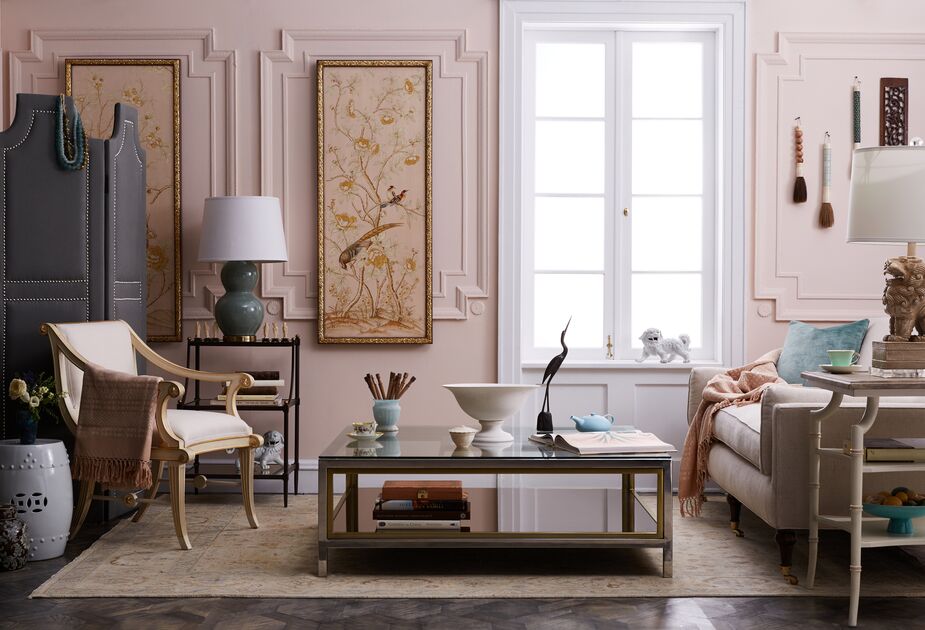 Dusky rose walls contribute to the serenity of this classically elegant living room. The even softer pink of the chinoiserie panels, the velvet sofa, and the rug ensure cohesiveness. Find the garden stool here.   
