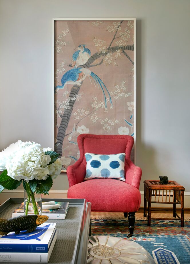 “The panel on the wall of this New York apartment inspired the palette for the room,” Leslie writes. “The raspberry-red chair and blue dots in the pillow echo its colors.” Using these colors as “anchors” allows the layering of varied patterns. Photo by Mark Roscams.
