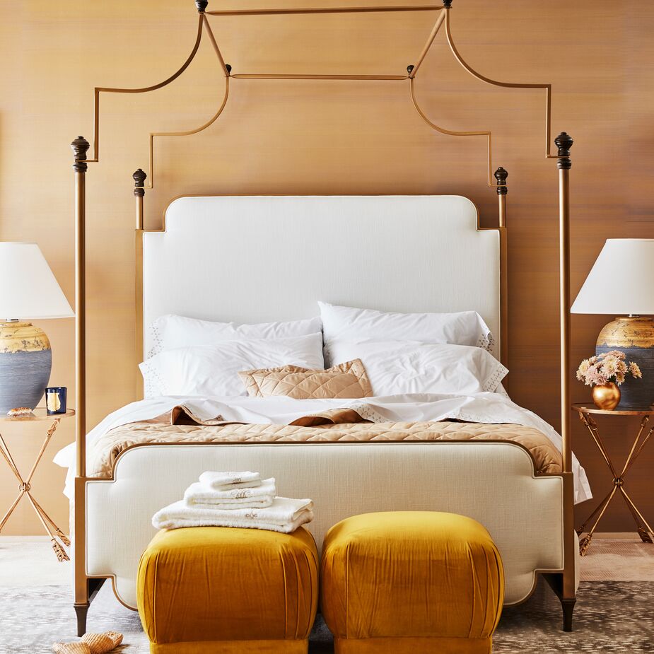 Even without curtains, the Loren Canopy Bed heightens a room’s drama, and its upholstered headboard provides added comfort. Find the ottomans here and the side tables here. Photo by Frank Frances.
