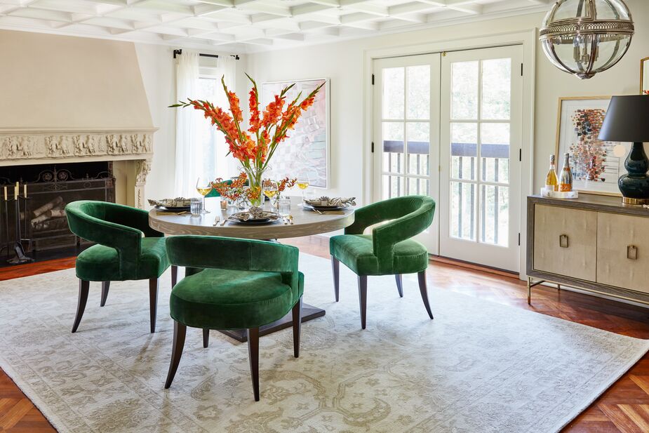 The barely-there green of the traditional rug lays the groundwork for the vibrant Ella Accent Chairs in Emerald Velvet. Photo by Frank Frances.
