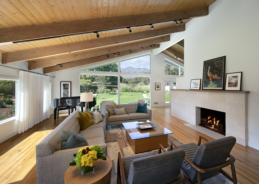 The woven fabric covering the sofa and settee, along with the channeled upholstery of the armchairs, softens the smooth surfaces that form the foundation of the living room.