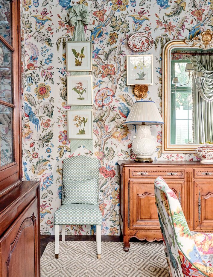 James Farmer is known for his love of color and pattern, which is on glorious display in this dining room. The side chairs’ checkerboard upholstery and the rug’s diamond motif (find a similar rug here) ease the transition between the flowery prints and the substantial antique furniture. (Explore a home designed by James Farmer here.)
