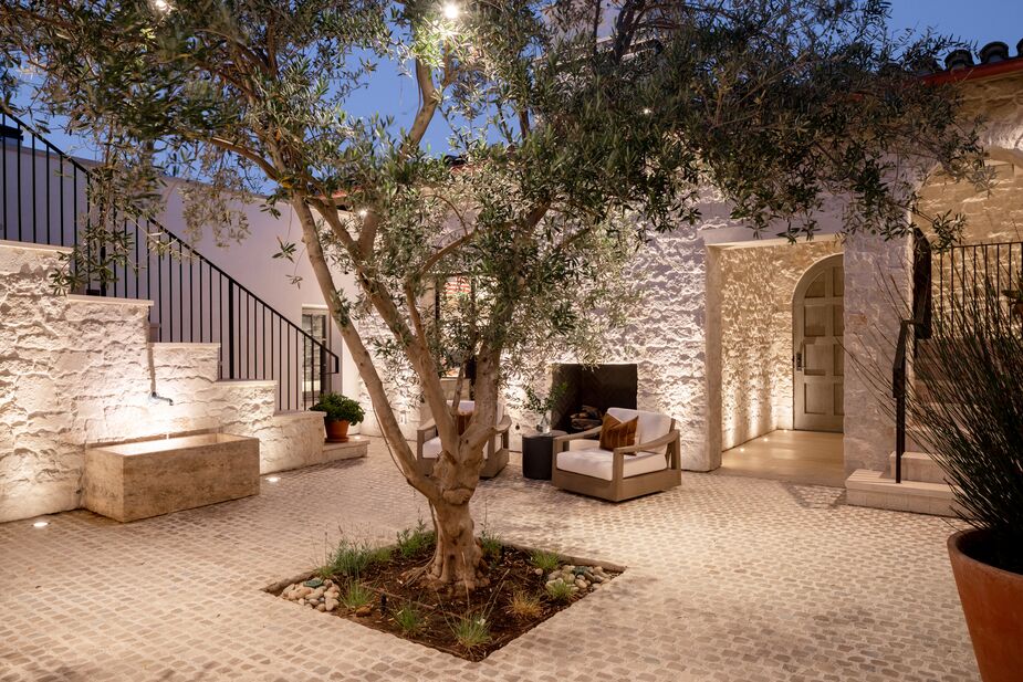 Antique Portuguese cobblestones form the base of the interior courtyard, with an olive tree serving as a centerpiece.
