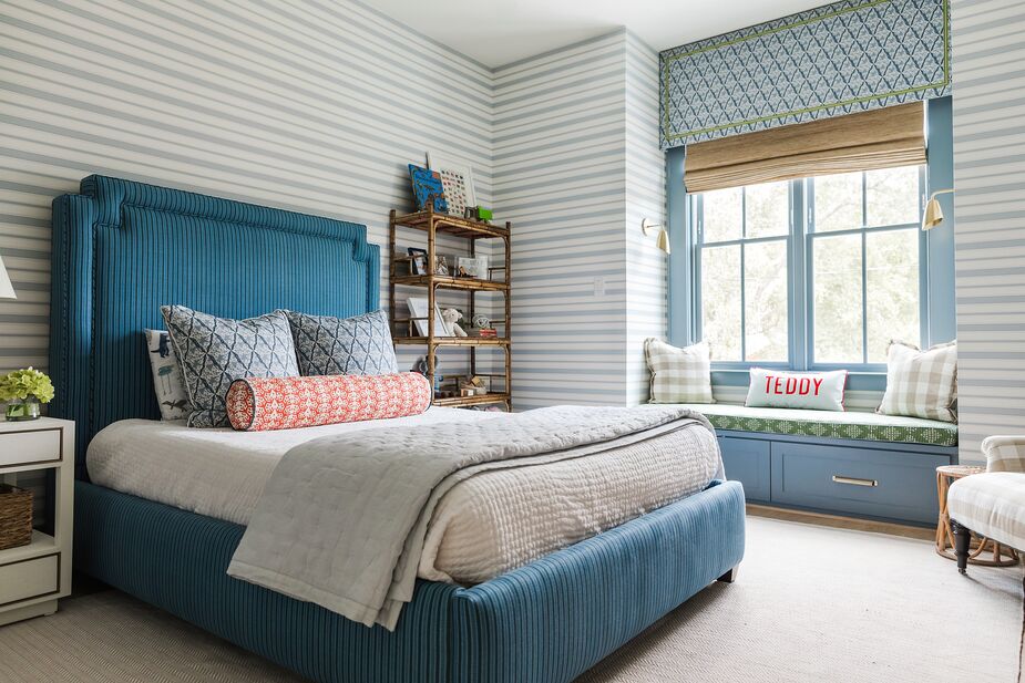 This room for a three-year-old boy “plays into typical little-boy colors—red, white, blue, and green—but in layered patterns to draw your interest across the space,” says designer Katie Davis. “We wanted to create a space that would grow with him and could also be used for guests if needed.” Photo by Melissa Fitzgerald West. 
