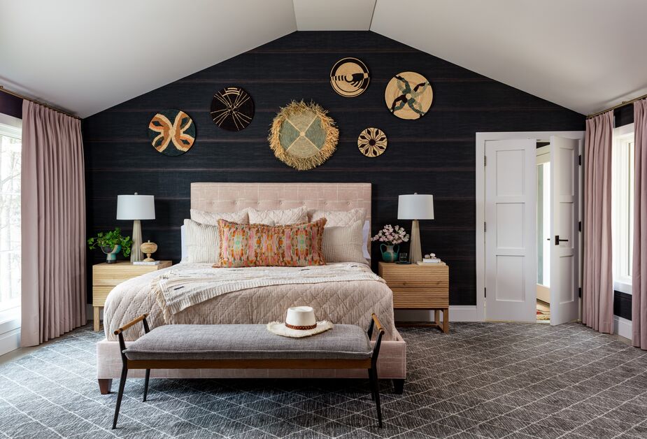 To balance the dark wallpaper that the client loved, Betsy introduced blush pink via the bed, bedding, and sateen curtains. “We hung a collection of handmade straw discs in a random pattern to fill the space above the bed. I just love the way they pop off the dark ground,” she writes.
