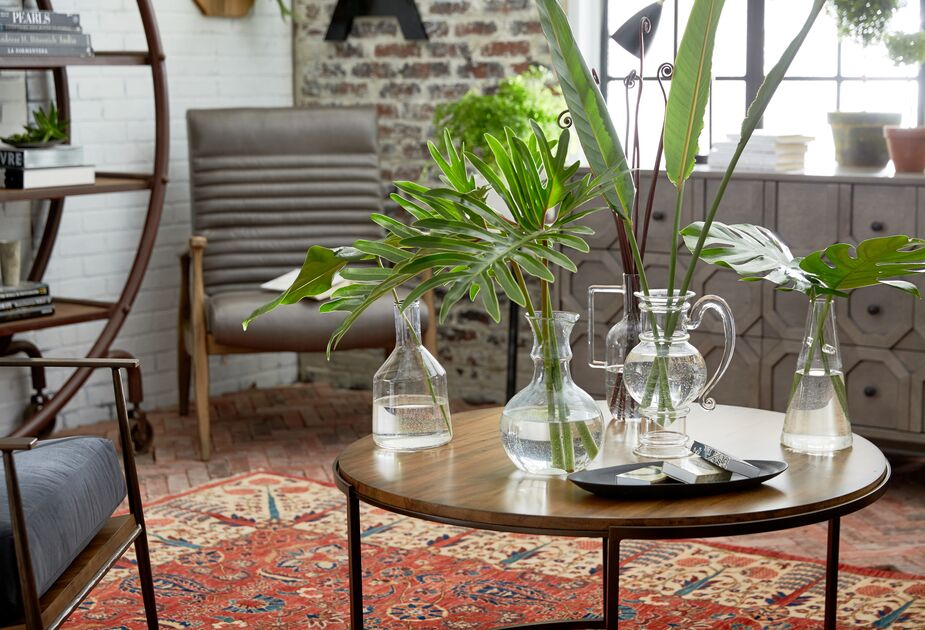You’ll be surprised how just a few fronds in clear glass vessels can give a space a conservatory ambience. The open shapes of the chairs, including the Erik Panel Chair in the corner, and table underscore the airy vibe.
