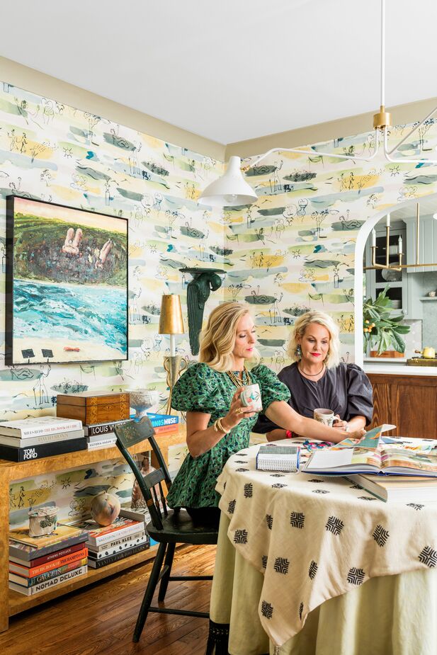 Designer Tami Ramsay (left) and client Susie Mobley in Susie’s dining room. The table can expand to accommodate a crowd, but when she’s not entertaining, Susie uses the room as a casual library. Find a similar chandelier here.
