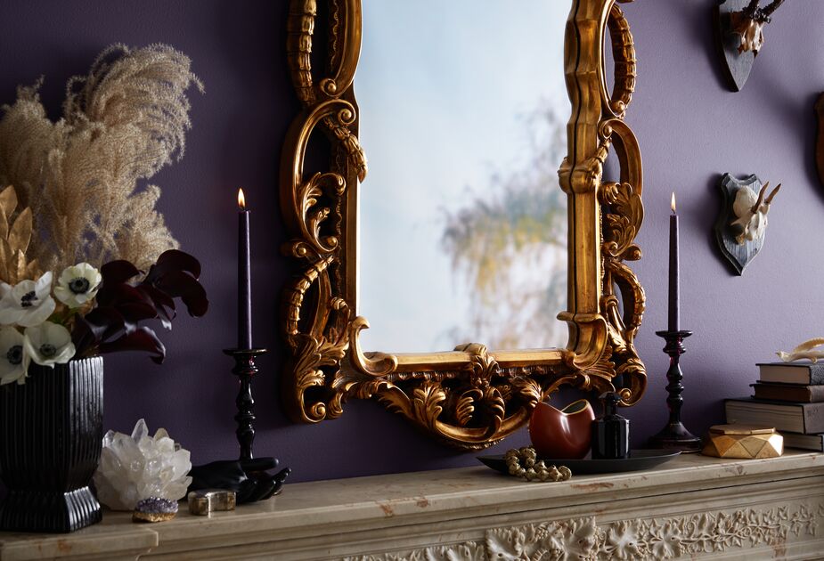 The black finish gives these otherwise traditional candleholders a goth mystique, especially with the moody wall color and the ornate mirror.
