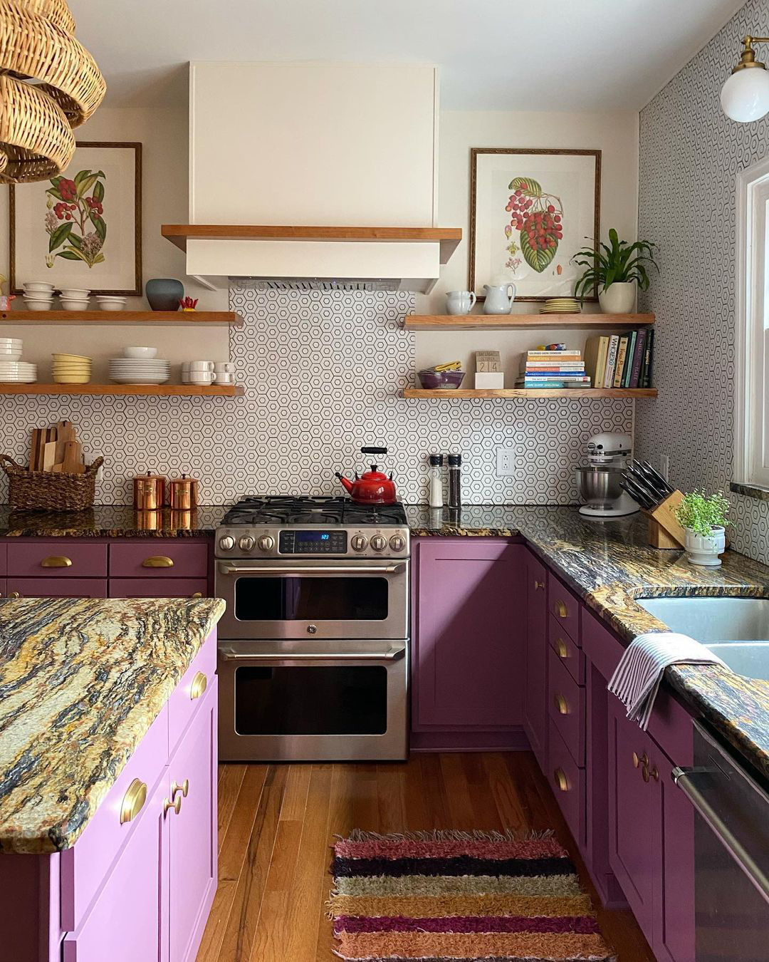 Andrea Granger of Hunt & Scavenge opted for plum cabinets to rev up this kitchen. The use of open shelving and pale neutrals above the counters keeps the room light and bright. Find the rattan chandelier here.
