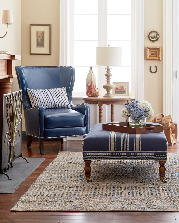 Silver nail heads call attention to this wingback chair‘s stately curves and sumptuous blue leather. 
