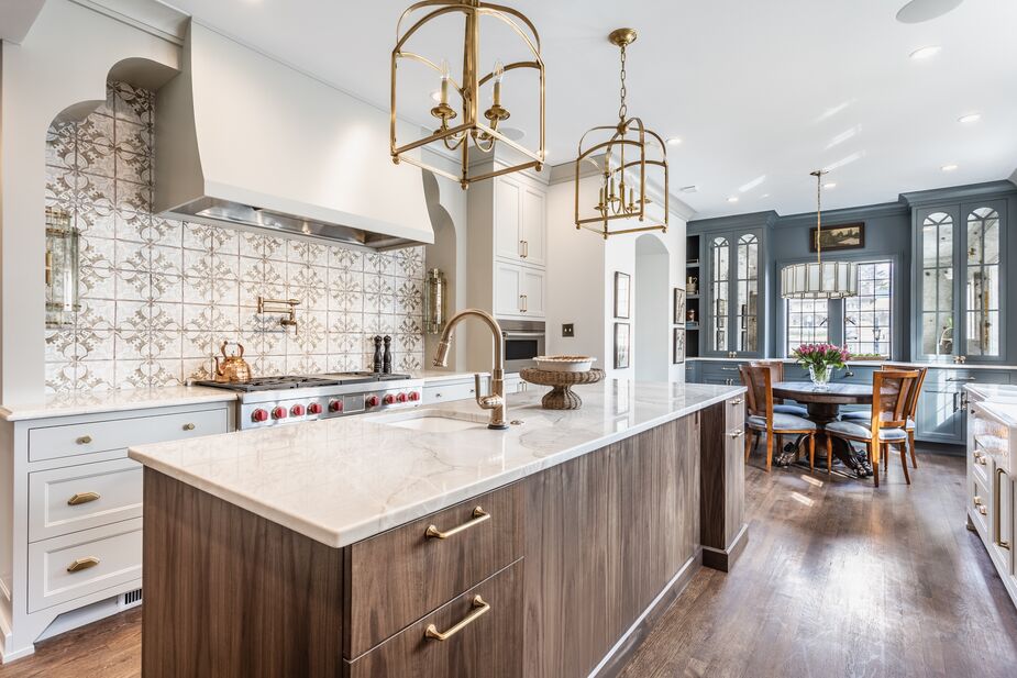 In this kitchen by Tiffany Skilling of Tiffany Skilling Interiors, there is no seating at the island, ensuring enough room to open cabinets and drawers easily. The eating area is instead tucked away at the end, making it easy for the cook to move about. Find similar lanterns here. Photo by the Addison Group.
