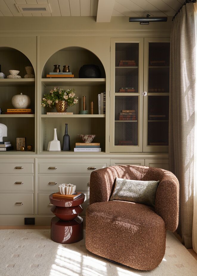 Curves were a theme throughout the show house. In this corner of a study, Geoffrey Coy of Coy & Co. incorporated arches into the custom cabinetry and a barrel swivel chair to balance the numerous straight lines and right angles inherent in just about every room. Find the picture light here. Photo by Mario Serafin Photography.
