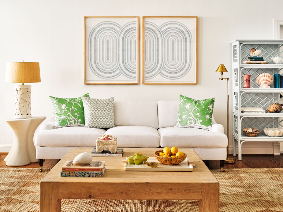 The green Cliveden Pillows, along with the Elliot Floral Pillow, pop against the Isadora Performance Linen Sofa in Snow. The Harwich Handwoven Rug contributes both organic texture and fanciful pattern. The light blue of the étagère echoes that of the Deco Diptych. Photo by Read McKendree.
