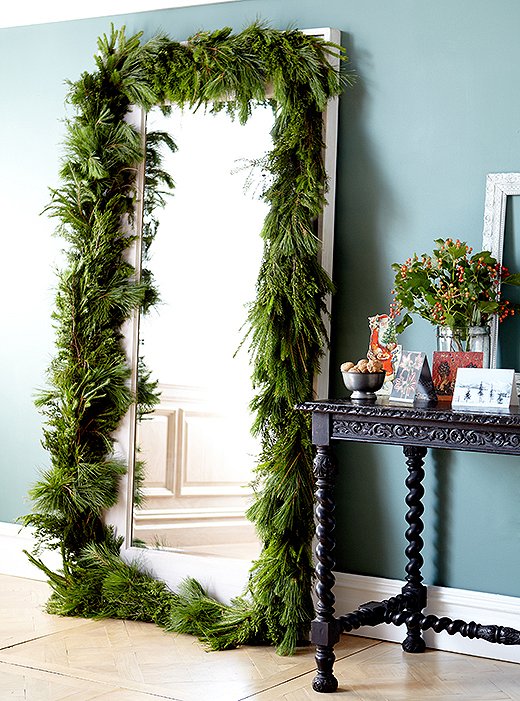 Speaking of garlands, more is more during the holidays. Use them to frame a mirror, a doorway, windows, or artwork. Drape them over kitchen cabinets while you’re at it, or wind them around the posters of your bed. Photo by Tony Vu.
