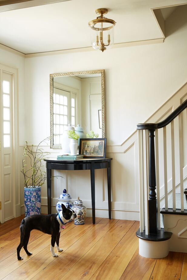 The simple demilune console keeps this entry from feeling cramped, as does using the space beneath the table for displaying ginger jars rather than stashing storage. But wait! Those ginger jars can hold pens and pencils, chargers, takeout menus, and other items.
