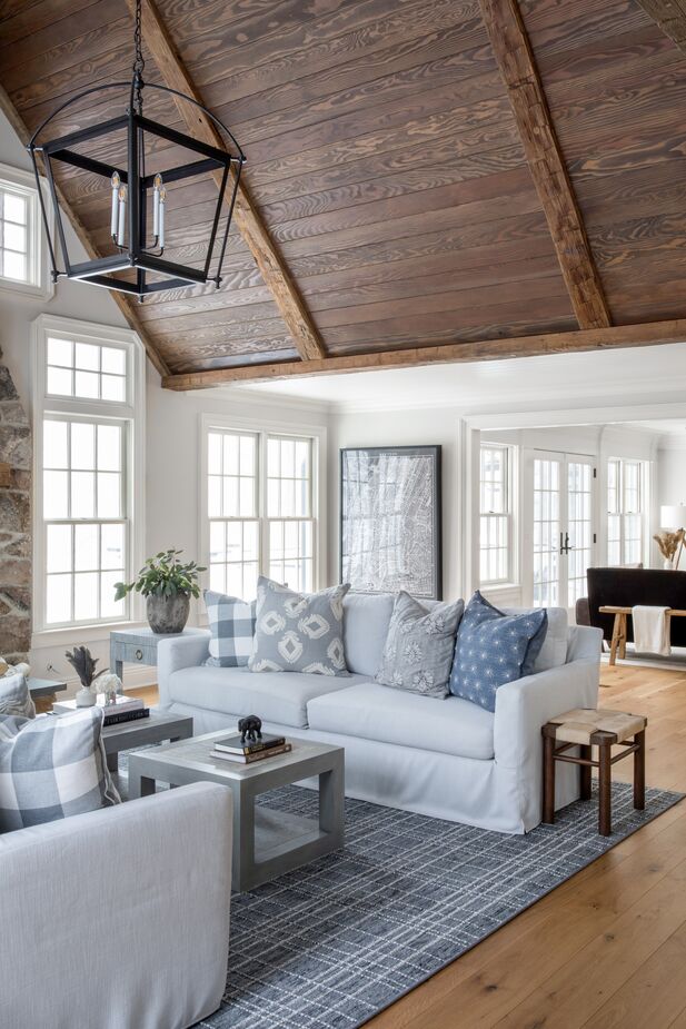 The dark wood planks of the family room’s vaulted ceiling provide a warm contrast to the rest of the light, bright space.
